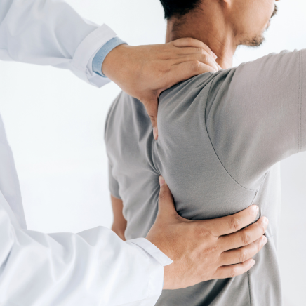 un kinésithérapeute masse le dos d'un patient