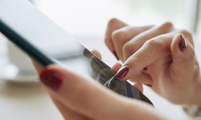 Une personne consulte une application mobile sur son smartphone.