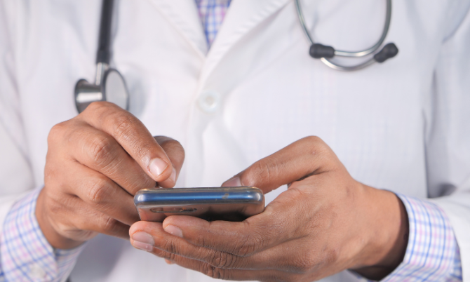 Un professionnel de santé utilise une application mobile sur son smartphone.